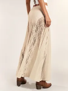 Detailed view of sheer floral lace and polka dot mesh panels on a cream maxi skirt