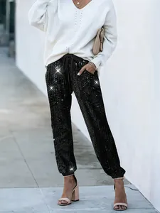Dettaglio di eleganti pantaloni jogger neri con paillettes e coulisse regolabile