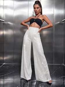 Close-up of white sequined high-waisted wide-leg trousers styled with a black crop top.