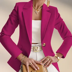 Detailansicht eines fuchsiafarbenen Blazers mit weißer Hose und goldenem V-Logo-Gürtel.