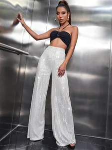 Elegant high-waist white sequined wide-leg pants shown on a model in a modern elevator
