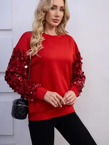 Primo piano della felpa rossa festiva con maniche di paillettes scintillanti su una modella