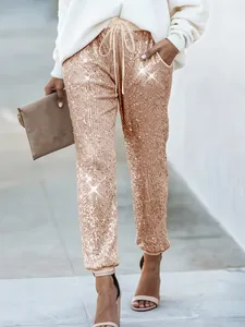 Primo piano di pantaloni con paillettes oro rosa da donna con coulisse e finitura lucida