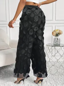 Full back view of elegant black high waisted mesh trousers with 3D polka dot applique