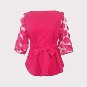 Elegante blusa fucsia con mangas de malla con pétalos 3D y detalle de lazo en la cintura.