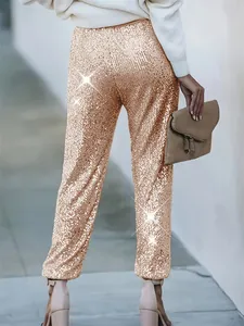 Vista posteriore degli eleganti pantaloni dritti con paillettes oro champagne da donna