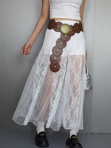 Detail view of white floral lace sheer maxi skirt styled with bohemian leather belt