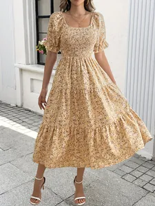 Detailansicht eines gelben floralen Midikleids mit gesmoktem Oberteil und Puffärmeln