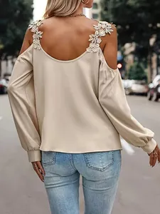Detailed back view of a beige cold shoulder top showing elegant floral lace strap accents.
