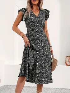 Detailed shot of a black and white floral midi dress with V-neck and front buttons