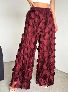 Close-up detail of burgundy mesh wide-leg pants with 3D polka dot petal appliqués