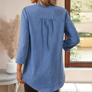 Vue arrière d'une chemise rétro en lin bleu à col en V et manches retroussées.