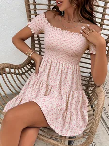 Close-up of floral off-shoulder French dress with shirred bodice and ruffled hem.