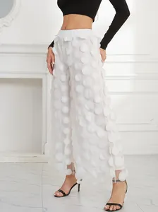 Detailed view of white mesh trousers featuring unique 3D polka dot applique texture