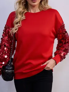 Dettaglio di una felpa rossa festiva con maniche di paillettes scintillanti per donna