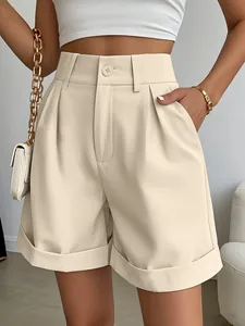 Detail of beige wide-leg summer shorts with high waist, pockets, and cuffed hem.