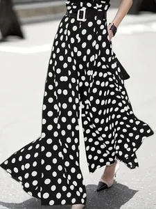 Detail view of high-waisted polka dot wide-leg trousers showing dynamic movement and fit