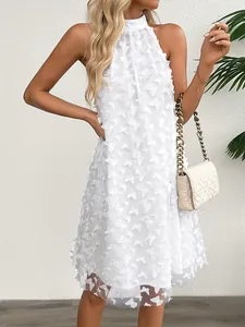 Detail of white French dress featuring 3D butterfly appliques and layered mesh fabric.