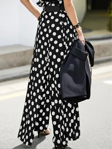 Close-up detail showing the flow of high-waisted black and white polka dot wide-leg culottes