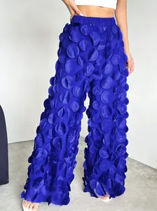 Detail view of royal blue wide-leg pants with 3D mesh floral appliqués for elegant women.