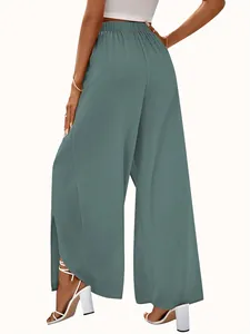 Side view of elegant high-waisted wide-leg trousers with side slits in teal color