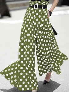 Detailed view of women's green high-waisted wide-leg pants featuring white polka dots
