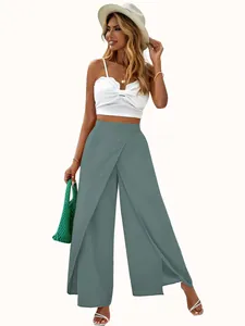 Detail of high-waisted wide-leg flowing trousers with elegant front split in dusty blue.