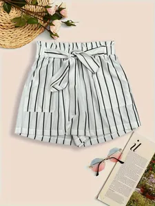 Close-up detail of stylish white and black vertical striped shorts with a matching tie belt.