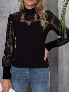 Close-up of black long sleeve top with intricate floral lace embroidery and high neck