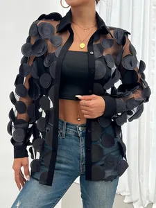 Gros plan détaillé des appliqués floraux 3D sur une chemise chic en maille noire transparente