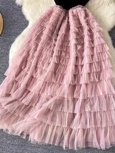 Primo piano di un'elegante gonna a balze in rete rosa con delicati volant e strati