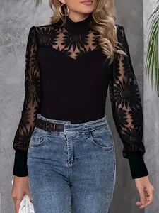 Detailed macro view of black lace long sleeve top featuring elegant floral embroidery patterns