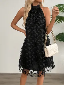 Detail shot of black halter dress featuring 3D butterfly appliques and mesh overlay