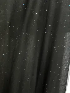 Close-up of black mesh fabric detail with delicate glittering star-like pattern