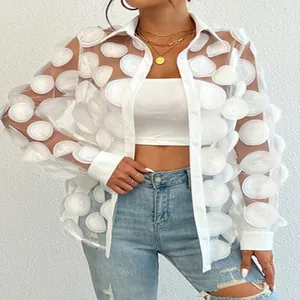 Vue détaillée d'une chemise en mesh blanc avec fleurs 3D et un top bandeau blanc