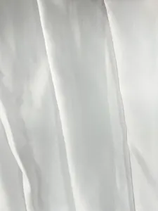 Close-up of elegant white fabric texture with soft pleated drapes.