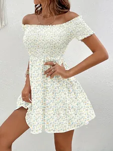 Close-up detail of smocked bodice and blue floral print on off-the-shoulder dress