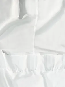 Close-up of elegant white maxi skirt showing delicate ruffles and high-quality fabric texture.