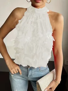 Detailed close-up of a chic white sleeveless halter top with layered fringe texture