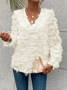 Gros plan d'une blouse blanche à col en V avec franges de plumes détaillées et textures