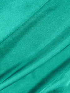 Vue détaillée montrant la texture lisse et l'éclat du tissu en satin turquoise