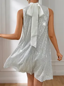 Rückendetail eines silbernen Pailletten-Partykleids mit weißer Satinschleife