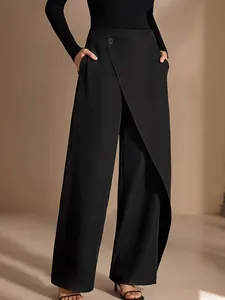 Close-up view of black asymmetric high-waisted wide-leg trousers with an elegant drape