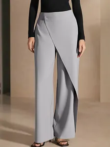 Detailed view of high-waisted asymmetrical wide-leg trousers in light grey woven fabric