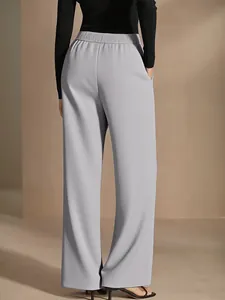 Back view of loose high-waisted wide-leg grey trousers with elegant drape and side pockets.