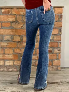 Back view of high-waisted flare jeans featuring delicate floral embroidery detail on legs