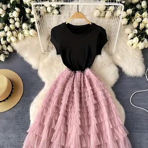 Elegante abito midi in tulle patchwork stile francese con top nero e gonna rosa a balze.