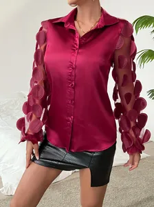Primo piano di camicia di raso bordeaux con maniche lunghe con applicazioni 3D uniche