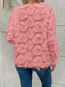 Détail du dos d'un chemisier rose à manches longues avec des franges et plumes