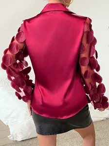 Vista posteriore di una camicia di raso fucsia con maniche a rete con applicazioni.